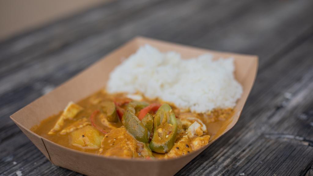 Yellow Curry · Yellow curry paste made from scratch with coconut milk, potatoes, red, and green bell peppers topped with serrano peppers.