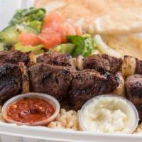 Beef Kebab · Two skewers spicy flame-broiled tender beef cubes served with rice, hummus, Greek salad, and...