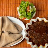 Yebere Siga Wot · Spicy beef stewed in red pepper sauce with an assortment of spices. Served with fresh salad ...