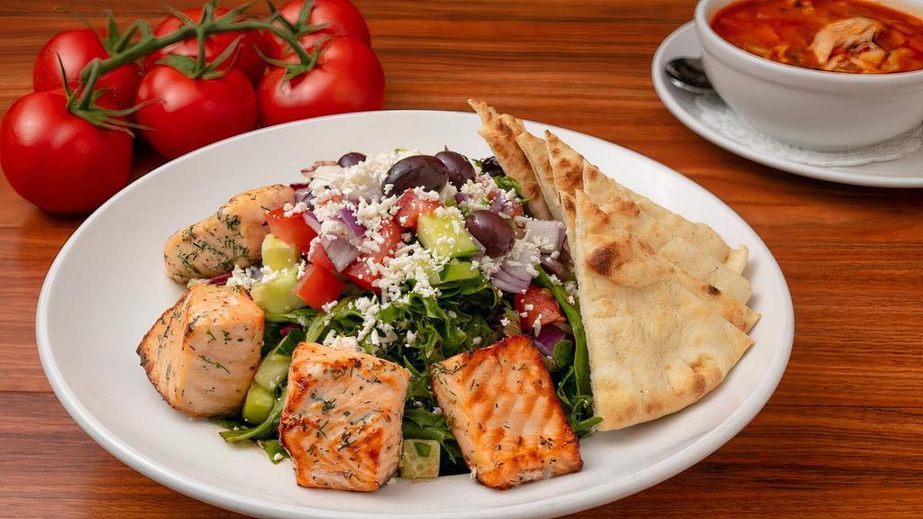 Mediterranean Salmon Salad · Grilled Atlantic Salmon on a Bed of Mixed Greens. Topped with Cucumber, Roma Tomatoes, Red Onion, Kalamata Olives, Feta Cheese, Lemon & Balsamic Vinaigrette.