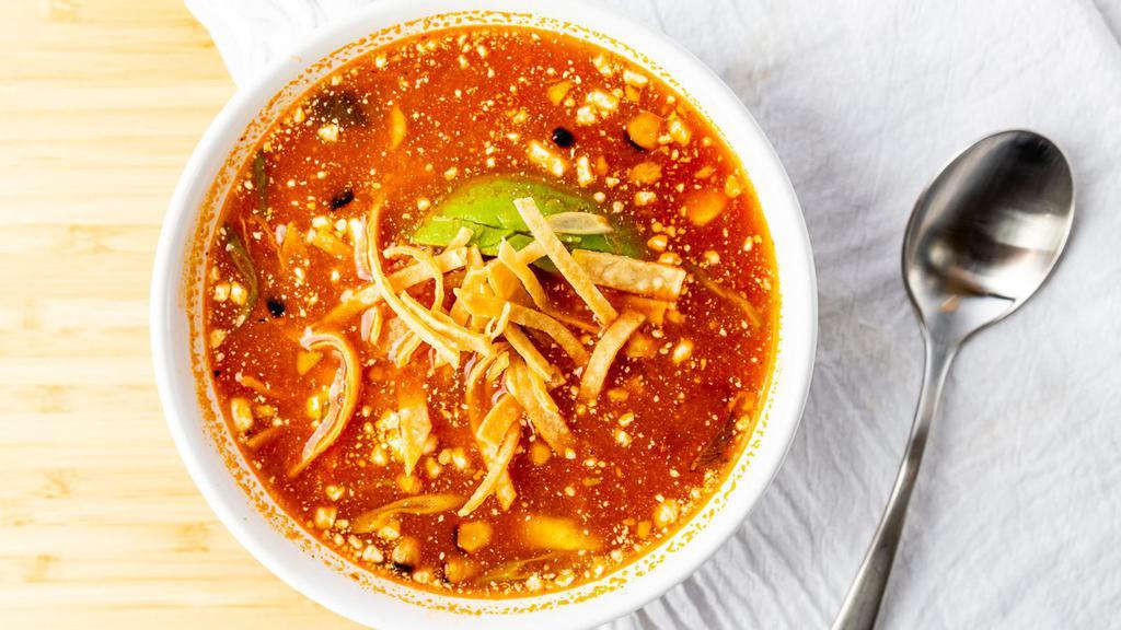 Tortilla Soup · Chicken tomato broth with shredded chicken, avocado, queso fresco, grilled corn, and tortilla strips garnished with sour cream and green onions.