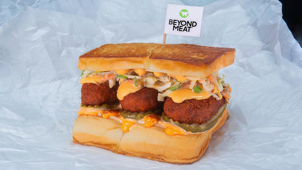 Beyond The Cheesy Chick · Two crispy fried Beyond® tenders, spiced to your liking, Plain, Nashville Hot or Nashville Hotter with dill pickle slices, slaw, white American cheese, cheese sauce and chipotle Aioli; served on King's Hawaiian rolls