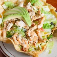Chicken Tostada · Cup-like tortilla shell covered with beans tossed greens and shredded chicken. Topped with h...