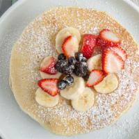Pancakes · Three pancakes and strawberry, banana, blueberry, powder sugar.