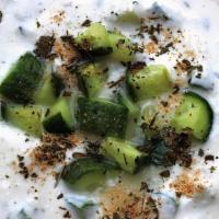 Maust Khiar · Creamy plain yogurt mixed with chopped fresh cucumber and dried mint seasoning.