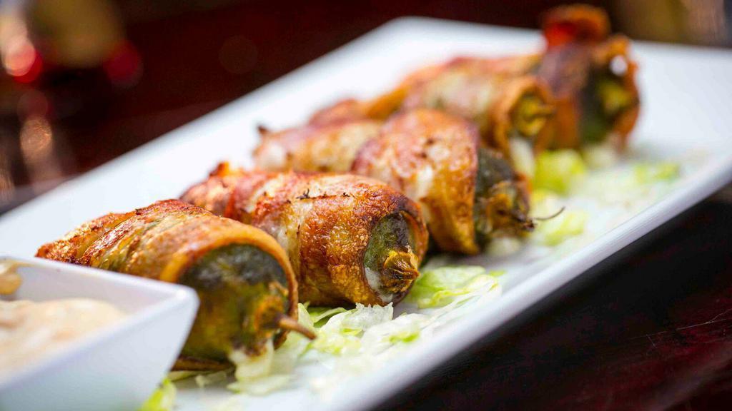 Bacon Jalapeño Poppers · Five fresh jalapeños wrapped in bacon, stuffed with Jack, mozzarella, and cream cheeses. Served with Cicada Ranch.