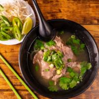 Beef · Rice noodle soup with sliced beef steak served with side of fresh herbs.