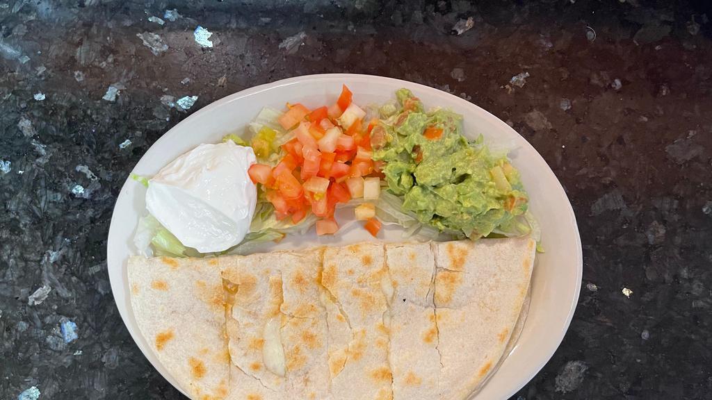 Quesadilla Appetizer · A flour tortilla filled with melted Monterey jack cheese with a side of sour cream, diced tomatoes, guacamole, and lettuce.