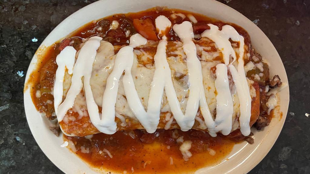 Burrito Supreme Dinner · Rice, beans, and your choice of meat in a flour tortilla, topped with your choice of red or green sauce, melted Monterey jack cheese, and a drizzle of sour cream.