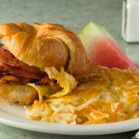 Breakfast Sandwich · A grilled croissant with two fresh eggs scrambled with a choice of  bacon, ham, or sausage, ...