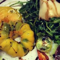 Heirloom Caprese Salad · Organic Heirloom tomatoes, fresh burrata cheese, basil oil, and aged balsamic vinegar. Veget...