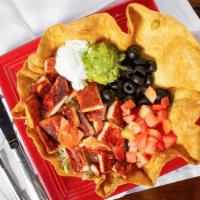 Tostada · A crisp flour tortilla covered with refried beans, layered lettuce and tomato with your choi...