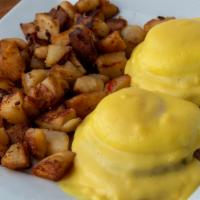 Eggs Benedict · English muffin topped with ham, poached eggs, and our house hollandaise sauce served with br...