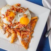 French Egg · French toast topped with two sunny side up eggs and bacon.