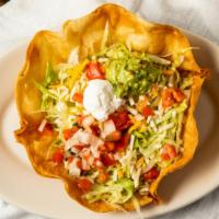 Taco Salad · Flour shell, layered with beef, chicken or pork, beans, lettuce, tomato, cream, guacamole an...