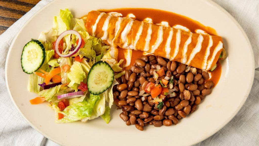 Veggie Enchilada · One large corn enchilada filled with sauteed peppers, mushrooms, onions, tomato, spinach and zucchini, covered in red sauce. Garnished with cream and cotija. Served with rice and pot beans.