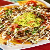 Nachos Con Carne ( Asada) · Refried beans, melted cheese, sour cream, and our signature guacamole with carne asada.