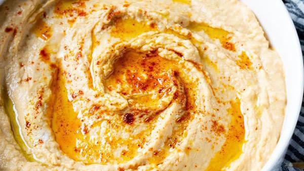 Hummus · Blended spread of garbanzo beans made with sesame paste, garlic and lemon juice, topped with virgin olive oil.