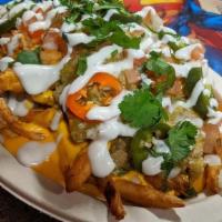 Chile Verde Nacho Fries · The best fries -crisp & seasoned- topped with scratch-made beans, queso, crema, tomatoes, on...
