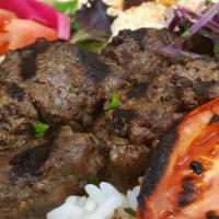 Lamb Kabob Plate · Flame broiled of lamb served with hummus, salad, rice, parsley, onion, grilled tomato and 2 ...