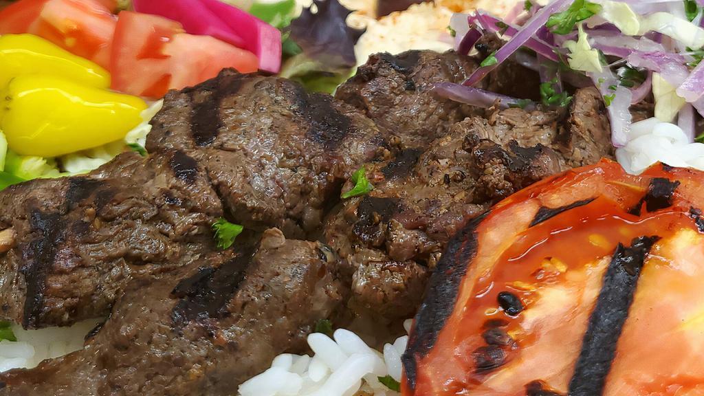 Lamb Kabob Plate · Flame broiled of lamb served with hummus, salad, rice, parsley, onion, grilled tomato and 2 pita bread.