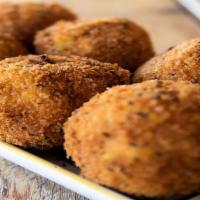 Arancini (Rice Ball) · A thick layer of rice stuffed with ground beef and peas, topped with meat sauce, served with...