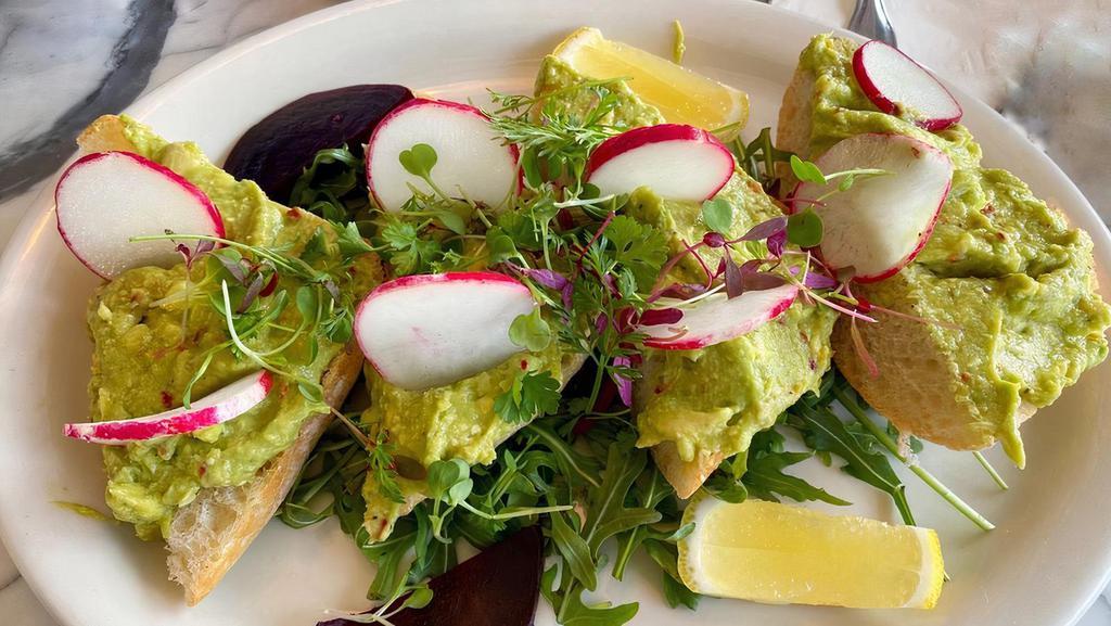 Smashed Avocado Toast · Open faced avocado toast, wild baby arugula, sliced radishes, lemons, salt, black pepper, & crushed red peppers, with a side of beets.