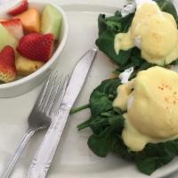 Eggs Florentine · English muffin topped with poached eggs, spinach, sliced tomato, & hollandaise sauce. Served...