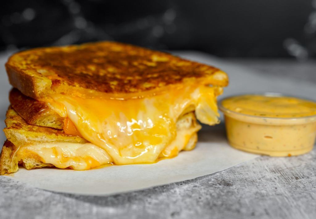 Three Cheese Monte Cristo · Cheddar, Swiss, and Parmesan cheeses melted between egg dipped, griddled sourdough bread. Served with a side of Spicy Honey Mustard Aioli.