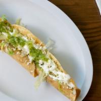 Flautas De Pollo · Bañadas en salsa de guacamole, crema y queso fresco.