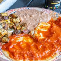 Huevos Rancheros Plate · 2 eggs over fried corn tortillas topped with spicy sauce; refried beans and potatoes on the ...