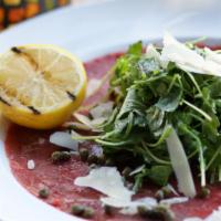 Carpaccio Prime · Gluten free. Prime filet of beef, capers, arugula, parmigiano, virgin olive oil, lemon.