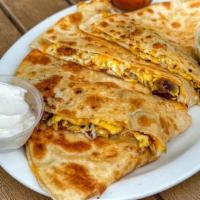 Bacon Breakfast Quesadilla · Cheese Quesadilla filled with scrambled eggs and meat. Comes with a side of Sour Cream and s...
