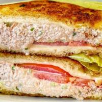 Tuna Melt · Tuna with cheese and tomato heated on the grill, on sourdough bread.