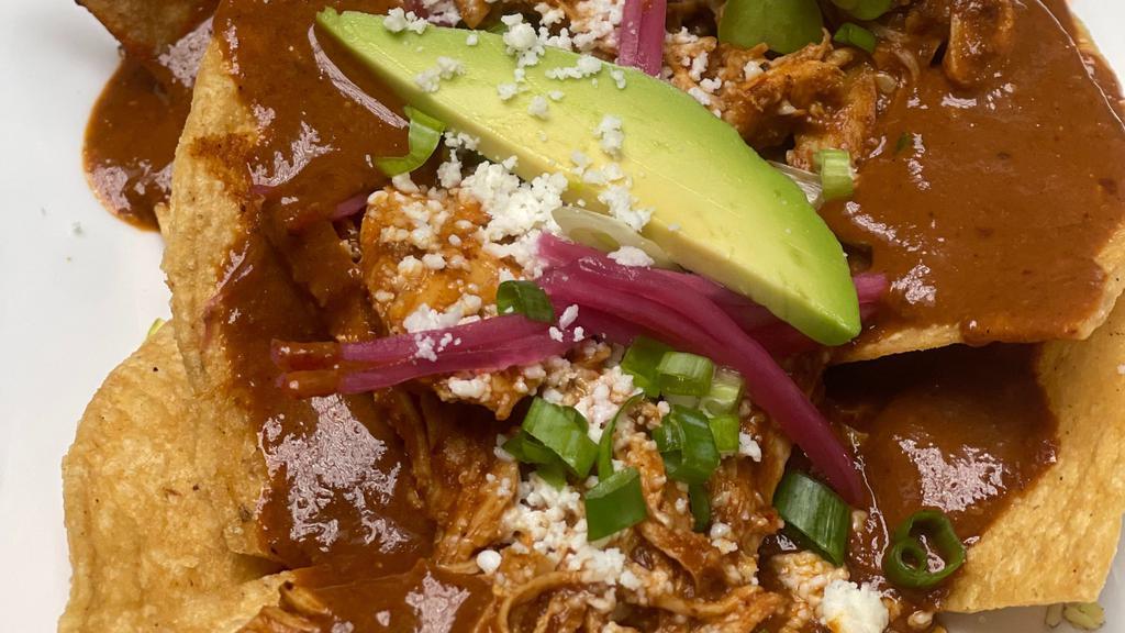 Mole Chicken Nachos · chips, traditional mole sauce topped with shredded chicken, cheddar & jack cheese, pickled onion, avocado, green onion & cotija cheese.