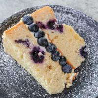 Lemon Berry Cake · Lemon cake with blueberries topped with powdered sugar.