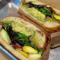 Veggie Avocado Sandwich · Grilled veggies, avocado, mushrooms, mixed greens, tomatoes, red onions, home-made pesto, Pr...