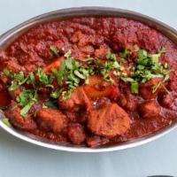 Lamb Vindaloo · Extra spiced lamb cooked with potatoes in a tangy, highly spiced sauce.