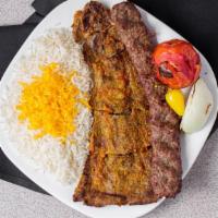 Beef Soltani Kabob · Skewers of char-broiled ground beef and flat marinated filet mignon sitting on top of white ...