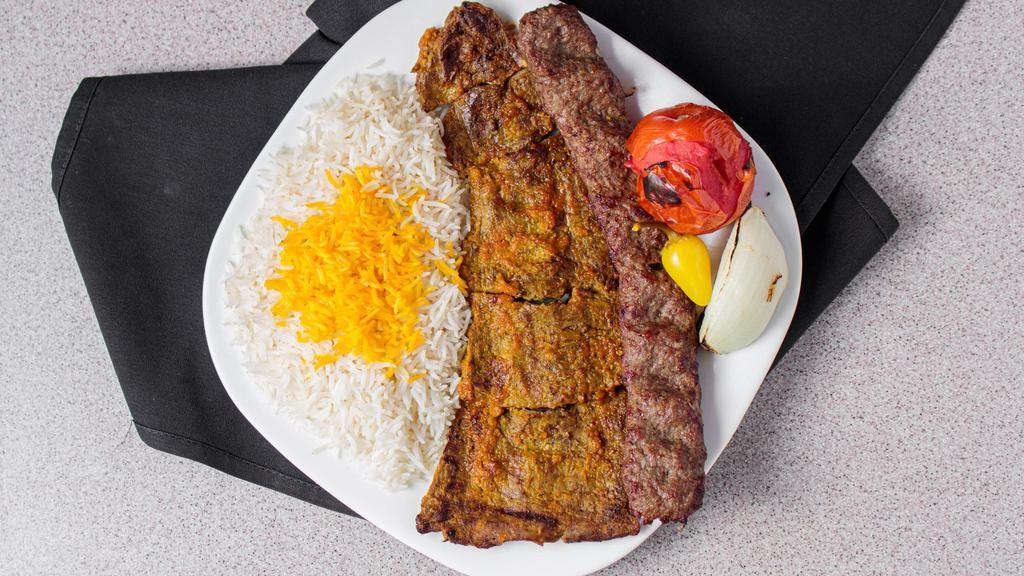 Beef Soltani Kabob · Skewers of char-broiled ground beef and flat marinated filet mignon sitting on top of white basmati rice topped with saffron, accompanied by a grilled tomato, onion, and covered by a pita bread. Gluten-Free