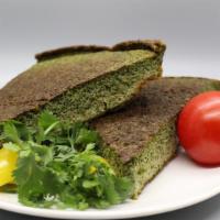 Kookoo Sabzi Sandwich · Kookoo sabzi sandwich served in a French roll topped with tomatoes onions and parsley with a...