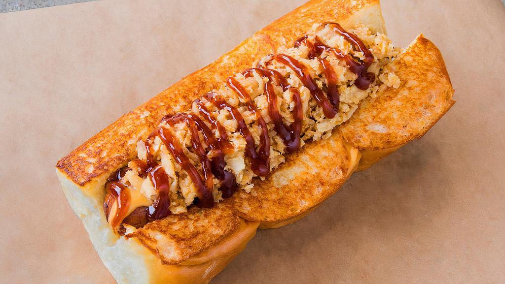 Cowboy Haus Dogs · Smoked bacon dog, Cheddar cheese sauce, crispy onions, and BBQ sauce on a king's Hawaiian roll.