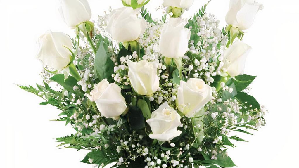 Dozen White Roses · A classic dozen of our finest white roses are truly the height of indulgence! Spoil someone special with the gift of twelve pure ivory roses sitting sweetly amongst a spray of sparkling white million star gypsophila and emerald green leaves. There's no better way to make a grand impression! A dozen gorgeous white roses are expertly arranged with baby's breath, leatherleaf, and salal in a classic clear glass vase.