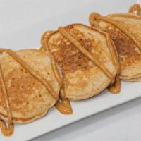 Peanut Butter Cream Pancakes · Three fluffy protein pancake with melted peanut butter on top.