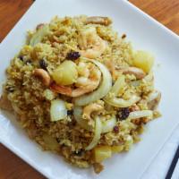 Pineapple Fried Rice · Curry powder scented fried rice with pineapples, cashew nuts, eggs, raisins, green onions, o...