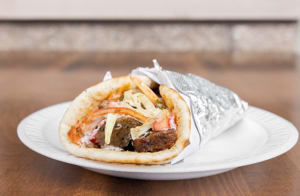 Gyro Wrap · Traditional beef and lamb gyro, wrapped in pita with lettuce, tomato, onions and white sauce.