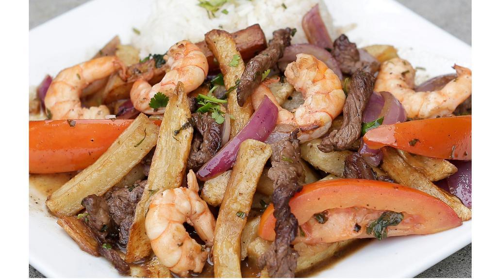 Mar Y Tierra · Beef strips and shrimps sauteed with onions, tomatoes, French fries and served with steamed rice.