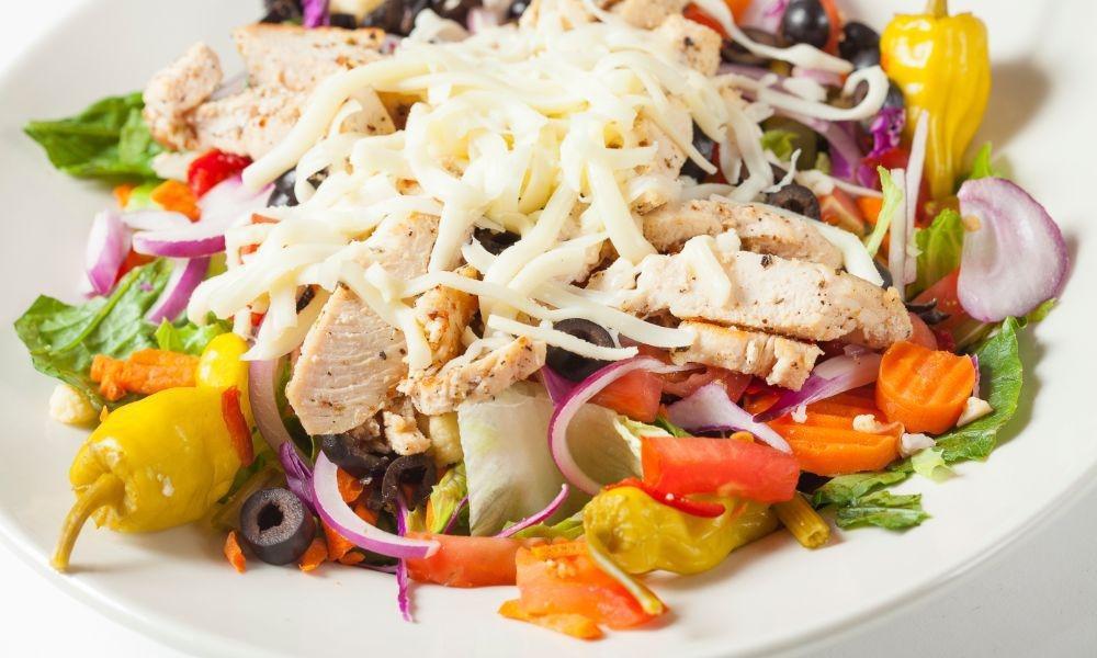 Italian Chicken Salad · Romaine lettuce topped with chicken breast, marinated vegetables, fresh tomatoes, onions, black olives & mozzarella cheese, served with Italian dressing