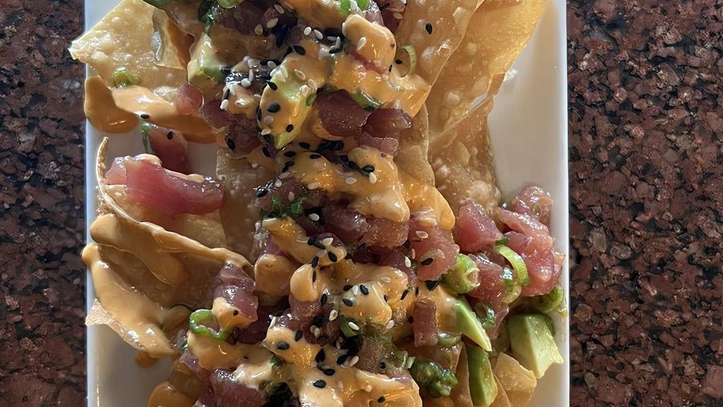 Ahi Nachos · House-made wonton chips topped with soy-ginger marinated ahi, seaweed salad, avocado, green onions with spicy garlic sauce & sesame seeds