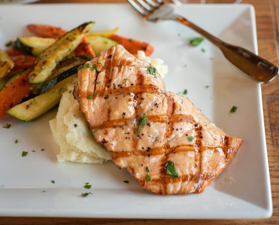 Grilled Salmon · Fresh Atlantic salmon with a light chardonnay sauce, served with garlic mashed potatoes and fire-roasted seasonal vegetables